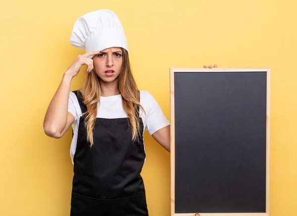 Chef Woman Feeling Confused Puzzled Showing You Insane Blackboard Menu — Stockfoto