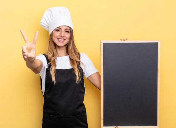 Chef Woman Smiling Looking Friendly Showing Number Two Blackboard Menu — Stockfoto