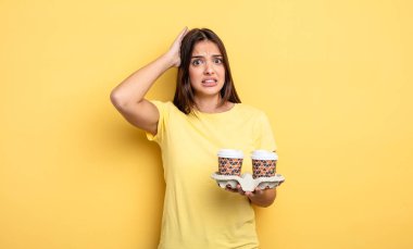 pretty woman feeling stressed, anxious or scared, with hands on head. take away coffee concept