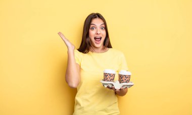 pretty woman feeling happy and astonished at something unbelievable. take away coffee concept