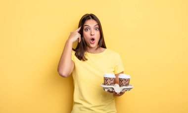 pretty woman looking surprised, realizing a new thought, idea or concept. take away coffee concept