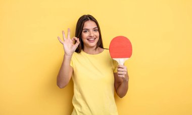 pretty woman feeling happy, showing approval with okay gesture. ping pong concept