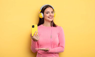 pretty woman smiling cheerfully, feeling happy and showing a concept. listening music concept