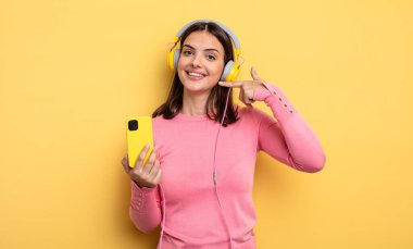 pretty woman smiling confidently pointing to own broad smile. listening music concept