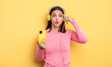 pretty woman looking surprised, realizing a new thought, idea or concept. listening music concept