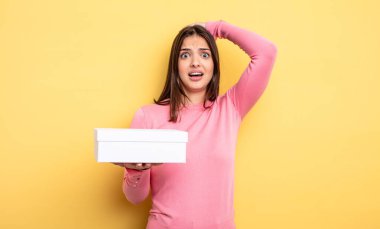 pretty woman feeling stressed, anxious or scared, with hands on head. white box packaging concept