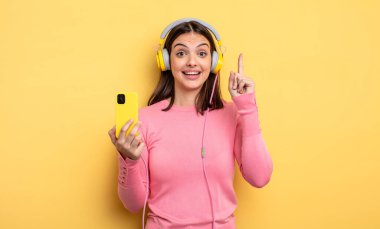 pretty woman feeling like a happy and excited genius after realizing an idea. listening music concept