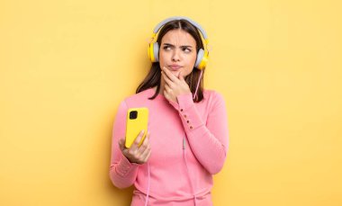pretty woman thinking, feeling doubtful and confused. listening music concept
