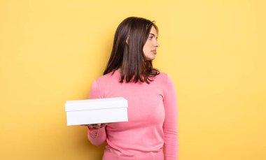 pretty woman on profile view thinking, imagining or daydreaming. white box packaging concept