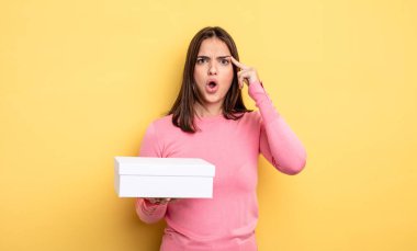 pretty woman looking surprised, realizing a new thought, idea or concept. white box packaging concept