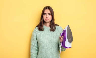 pretty woman feeling sad and whiney with an unhappy look and crying. iron clothes concept