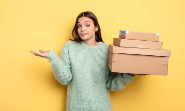 pretty woman feeling puzzled and confused and doubting packages boxes concept