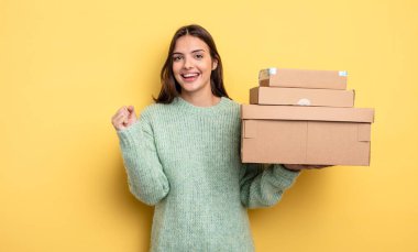 pretty woman feeling shocked,laughing and celebrating success packages boxes concept