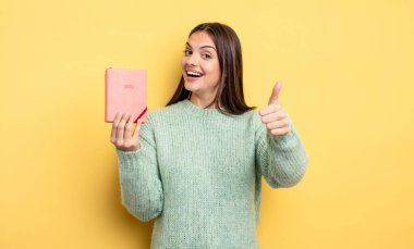 Güzel bir kadın gururlu, olumlu gülümsüyor. planlayıcı konsepti