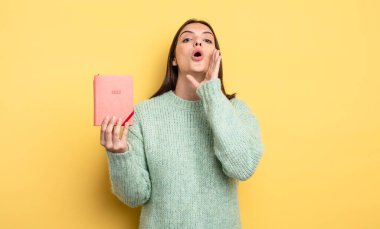 Güzel bir kadın kendini mutlu hissediyor, elleri ağzının kenarında bağırıyor. planlayıcı konsepti