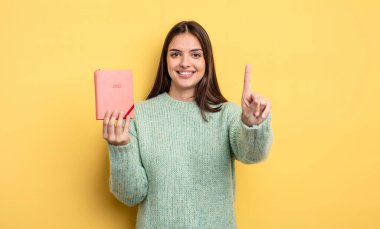 Güzel bayan gülümsüyor ve arkadaş canlısı görünüyor, bir numarayı gösteriyor. planlayıcı konsepti