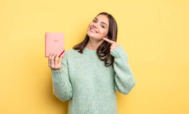 Kendine güvenen güzel bir kadın kendi gülüşünü işaret ediyor. planlayıcı konsepti