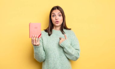 Şok olmuş ve ağzı açık, kendini gösteren güzel bir kadın. planlayıcı konsepti