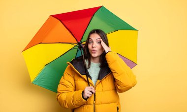 pretty woman looking happy, astonished and surprised. winter and umbrella concept