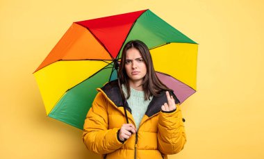 pretty woman feeling angry, annoyed, rebellious and aggressive. winter and umbrella concept