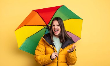 pretty woman looking angry, annoyed and frustrated. winter and umbrella concept