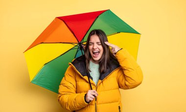 pretty woman looking unhappy and stressed, suicide gesture making gun sign. winter and umbrella concept