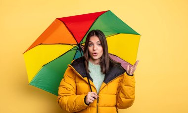 pretty woman feeling extremely shocked and surprised. winter and umbrella concept