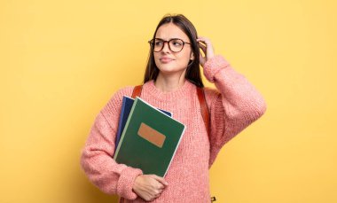 pretty student woman smiling happily and daydreaming or doubting