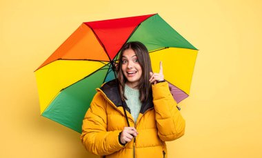 pretty woman feeling like a happy and excited genius after realizing an idea. winter and umbrella concept