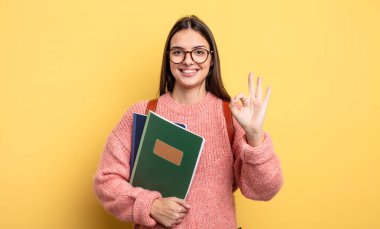 pretty student woman feeling happy, showing approval with okay gesture