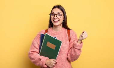 pretty student woman feeling shocked,laughing and celebrating success