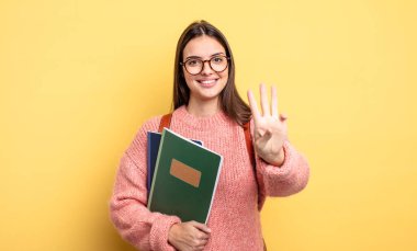 pretty student woman smiling and looking friendly, showing number three