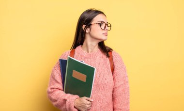 pretty student woman on profile view thinking, imagining or daydreaming