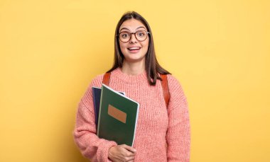 pretty student woman looking happy and pleasantly surprised