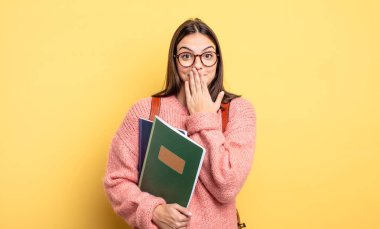 pretty student woman covering mouth with hands with a shocked