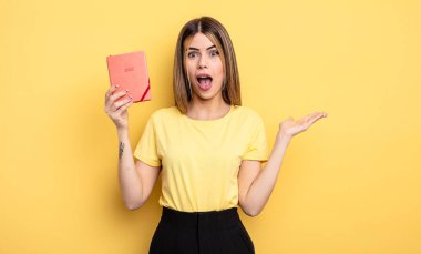 Güzel bir kadın kendini mutlu hissediyor ve inanılmaz bir şeye hayret ediyor. planlayıcı konsepti