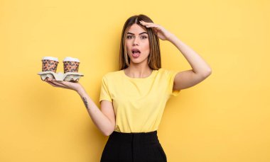 Güzel kadın mutlu, şaşkın ve şaşırmış görünüyor. kahve konseptini kaldır.