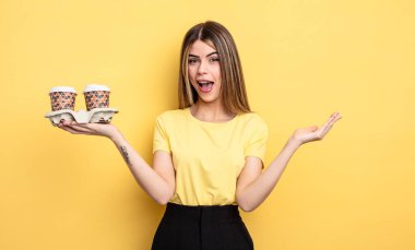 Güzel bir kadın kendini mutlu hissediyor ve inanılmaz bir şeye hayret ediyor. kahve konseptini kaldır.