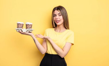 Güzel bir kadın neşeyle gülümser, mutlu hisseder ve bir konsept gösterir. kahve konseptini kaldır.