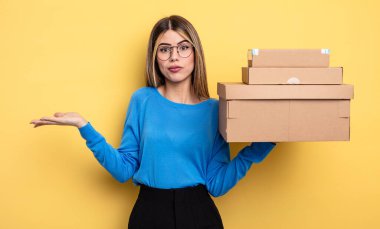 pretty woman feeling puzzled and confused and doubting packages boxes concept