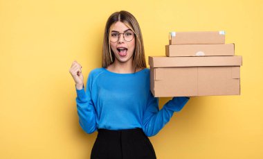 pretty woman feeling shocked,laughing and celebrating success packages boxes concept