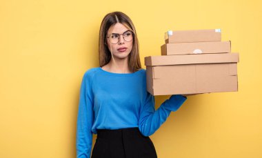 pretty woman feeling sad, upset or angry and looking to the side packages boxes concept
