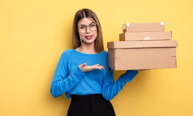 Güzel bir kadın neşeyle gülümser, mutlu hisseder ve bir konsept kutu konsepti gösterir.