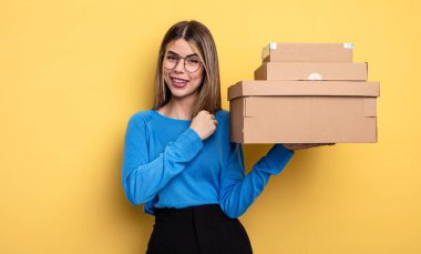 Güzel bir kadın kendini mutlu hisseder ve bir meydan okumayla yüzleşir ya da paket kutuları konseptini kutlar