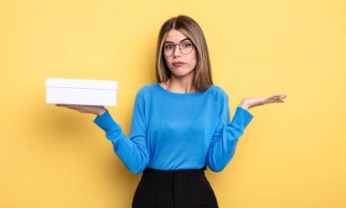 Güzel bir kadın şaşkın, şaşkın ve şüpheci hissediyor. Beyaz kutu tutuluyor