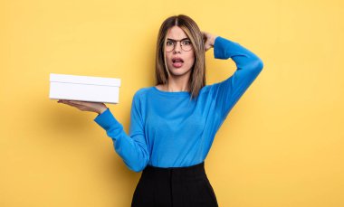 Güzel bir kadın stresli, endişeli ya da korkmuş hissediyor. Elleri başının üstünde. Beyaz kutu tutuluyor