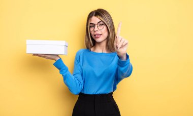 Güzel bayan gülümsüyor ve arkadaş canlısı görünüyor, bir numarayı gösteriyor. Beyaz kutu tutuluyor