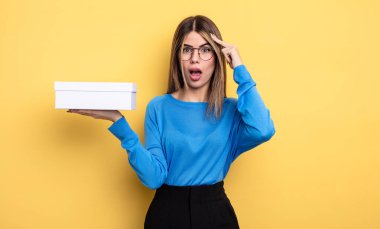 Güzel kadın şaşırmış görünüyor, yeni bir düşünce, fikir ya da konsept fark ediyor. Beyaz kutu tutuluyor