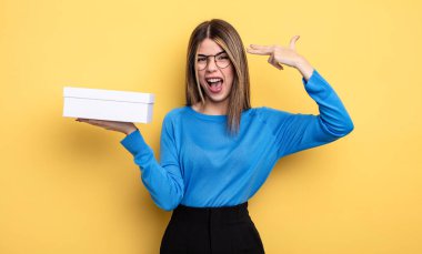 Güzel bir kadın mutsuz ve stresli görünüyor, intihar jesti silah işareti yapıyor. Beyaz kutu tutuluyor