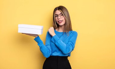 Güzel bir kadın kendini mutlu hisseder ve bir meydan okumayla yüzleşir ya da kutlama yapar. Beyaz kutu tutuluyor